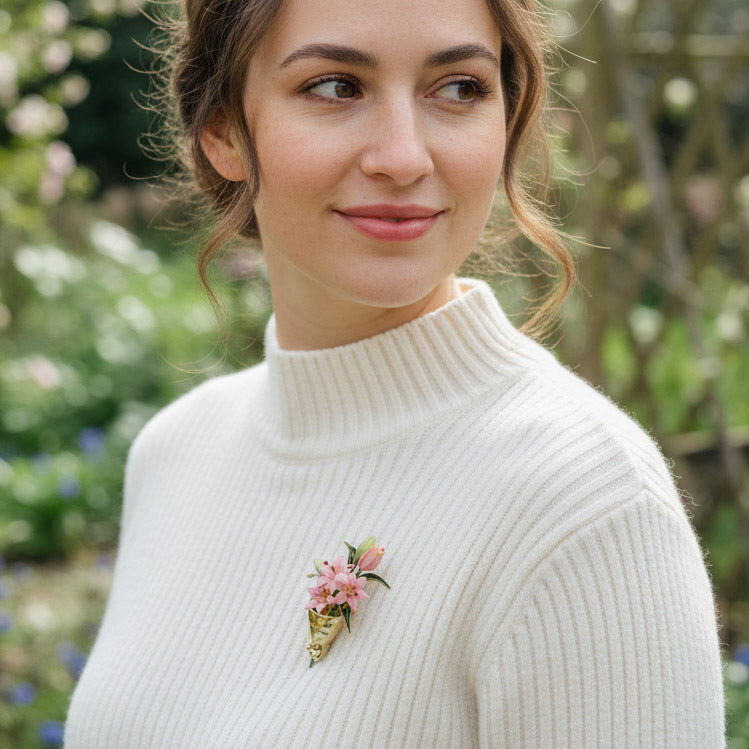 Woman wearing a white sweater with a floral brooch outdoors