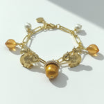 Gold bracelet with charms on a white background