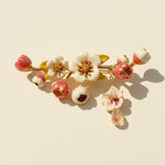 Floral brooch with pink and white flowers on a beige background