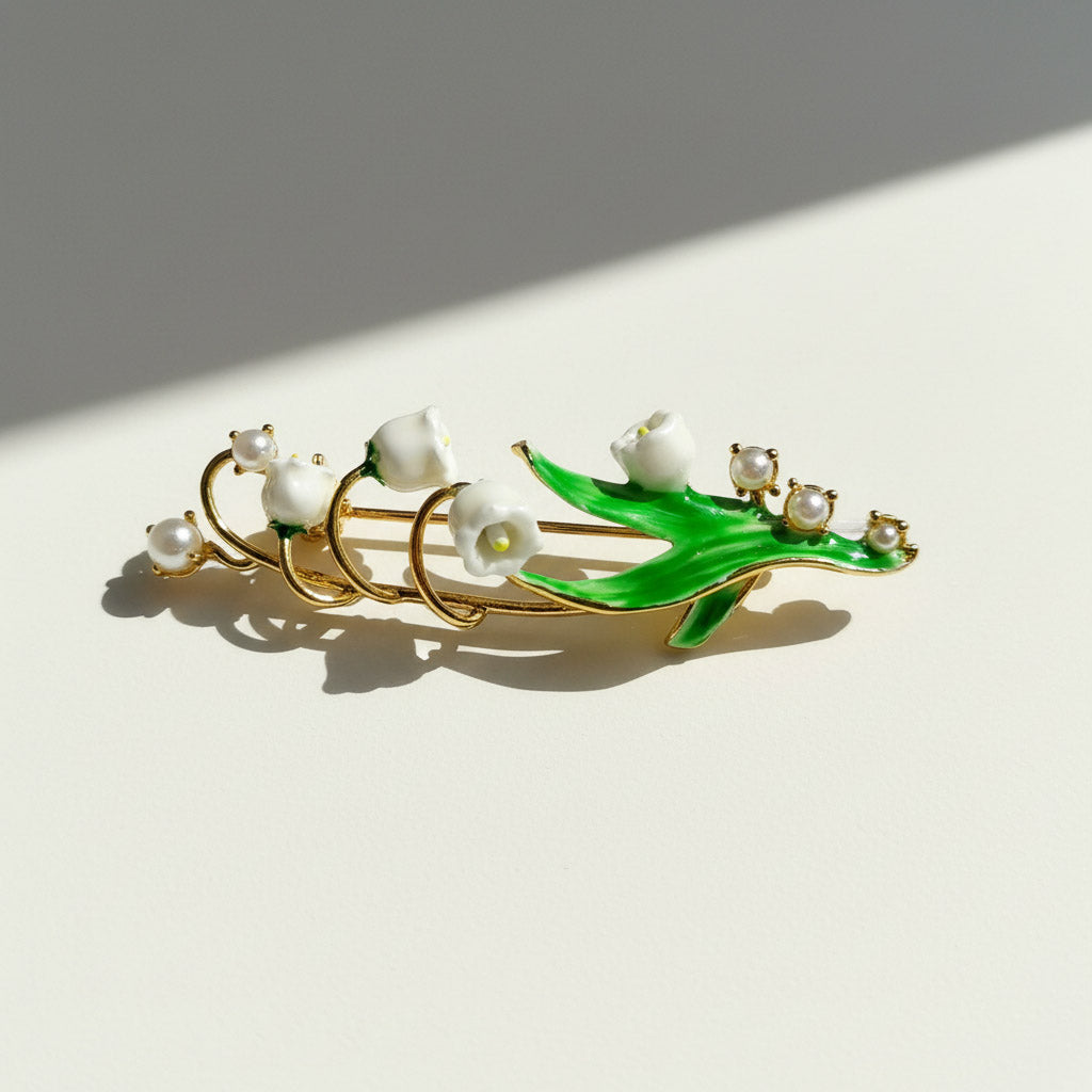 Jewelry piece with pearls and green leaf design on a light background