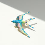 Colorful bird-shaped hair clip on a light gray background