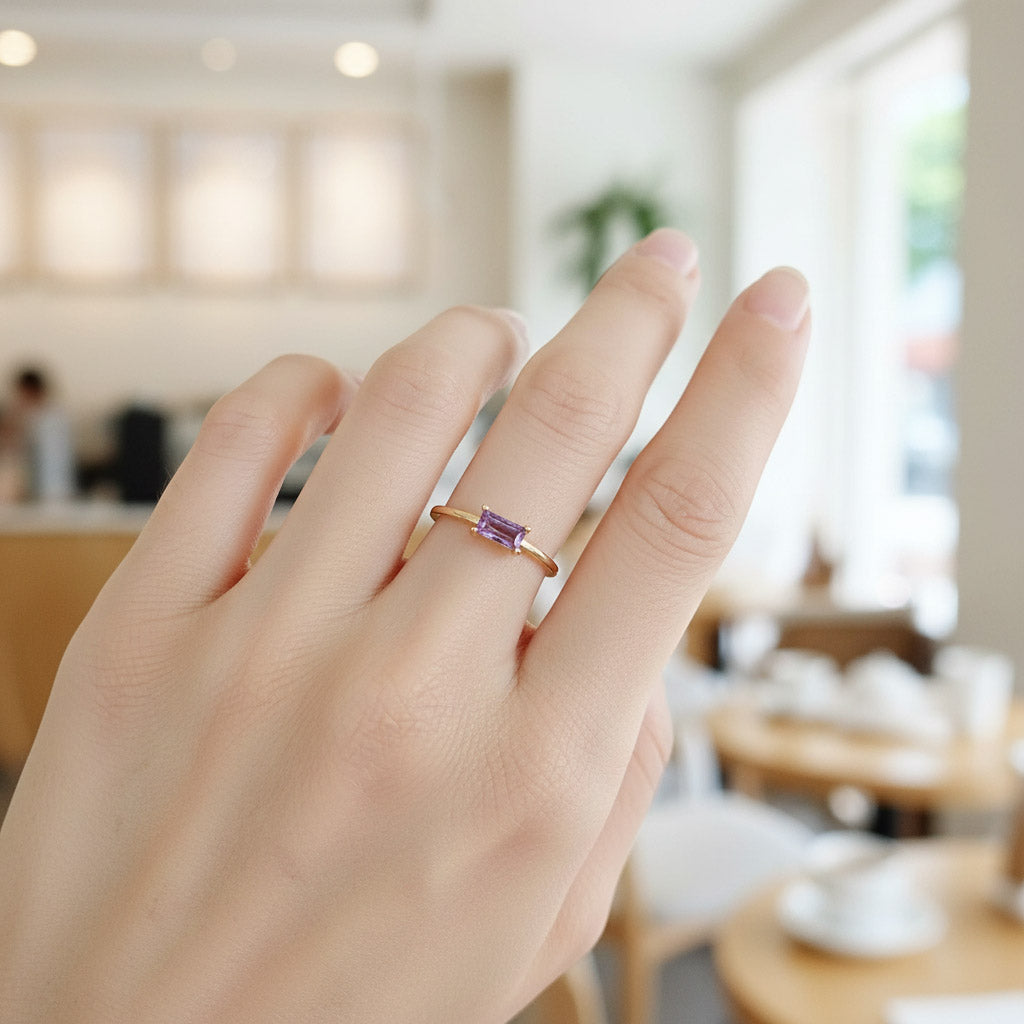 Gold-plated silver adjustable ring with rectangular purple CZ birthstone shown on hand, minimalist design by A2K London.