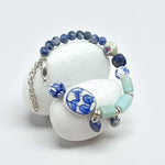 Beaded bracelet with blue and white floral patterns on a white background