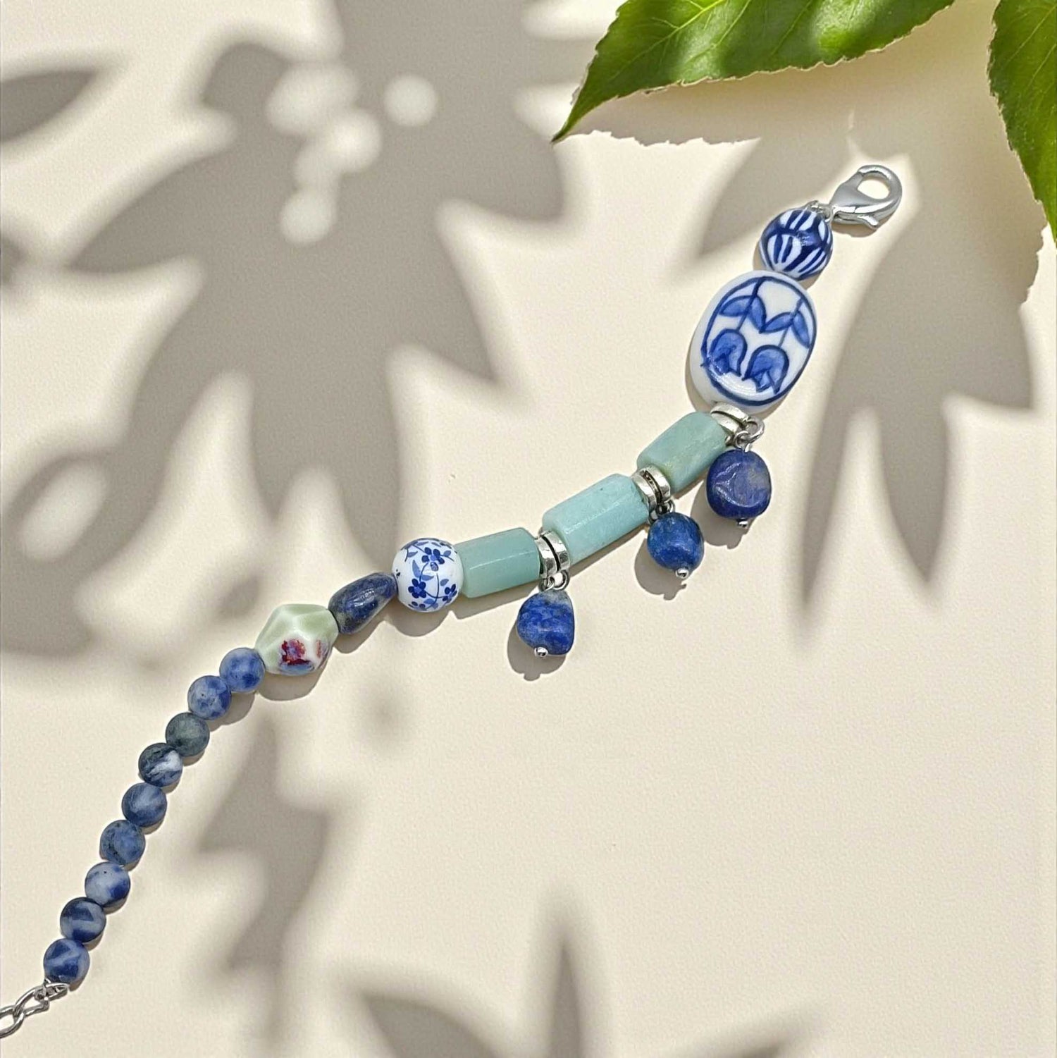 Porcelain bead and semi-precious stone bracelet with blue and green accents.