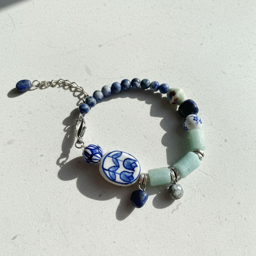 Bracelet with blue and green beads on a light gray background