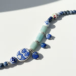 Necklace with blue and white floral beads on a white background