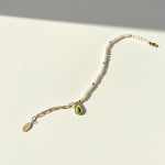 Freshwater pearl bracelet with CZ paved avocado charm in 18K gold-plated brass on a white background