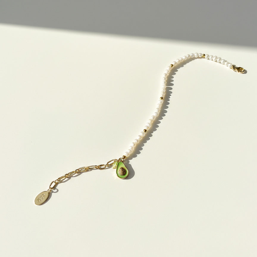 Freshwater pearl bracelet with CZ paved avocado charm in 18K gold-plated brass on a white background