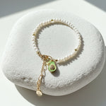 Freshwater pearl bracelet with CZ paved avocado charm on a white stone