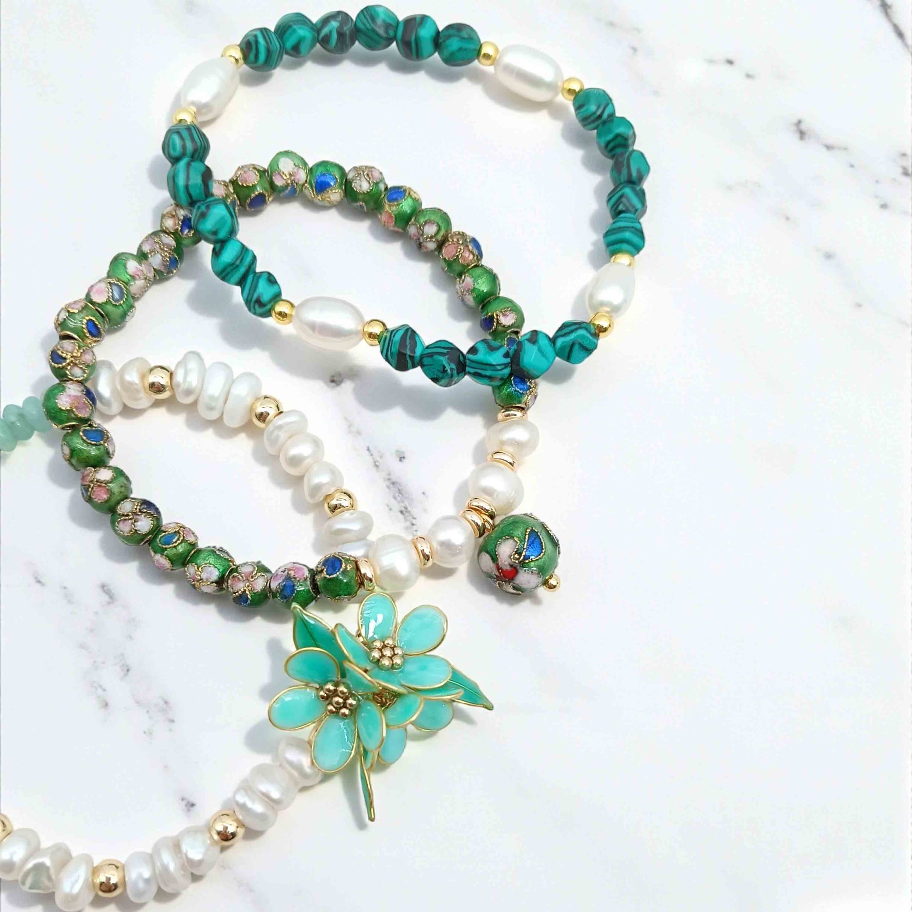Beaded necklace with a floral pendant on a light background