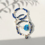Sodalite and lapis floral beaded bracelet set with freshwater pearls on a white background