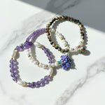 Amethyst and freshwater pearl bracelet set with handcrafted resin flower on a marble surface