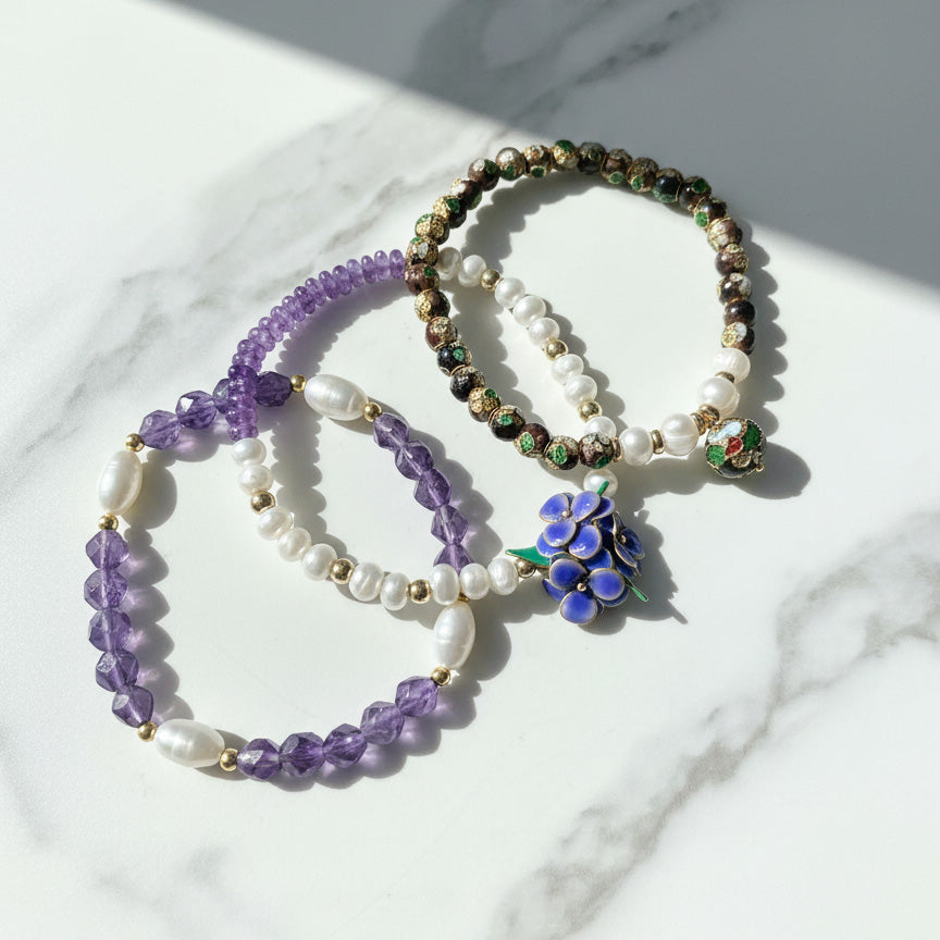 Amethyst and freshwater pearl bracelet set with handcrafted resin flower on a marble surface