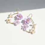 Floral and pearl earrings on a light background
