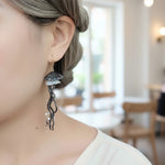 Person wearing a unique earring with a blurred indoor background