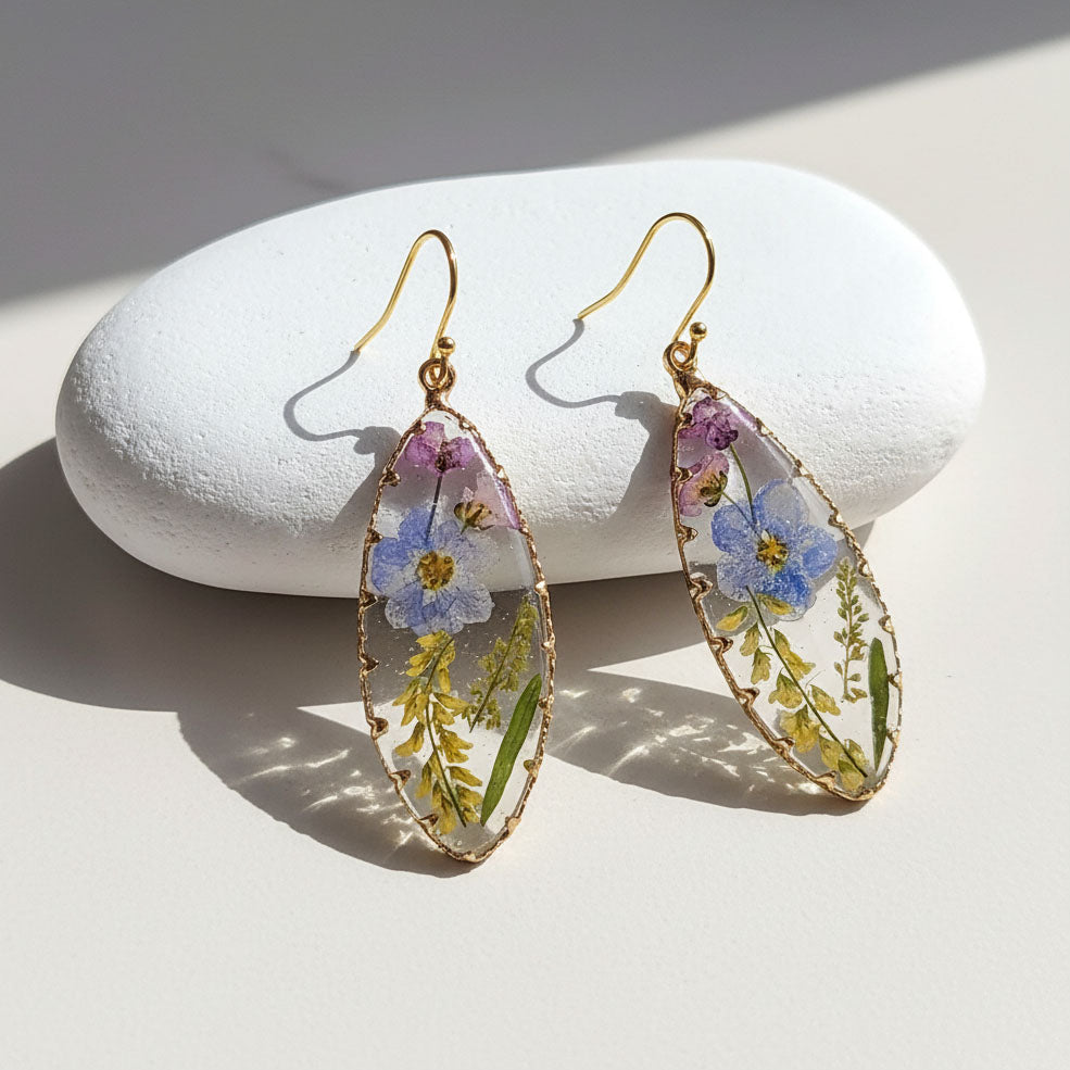 Pair of floral earrings on a white stone surface