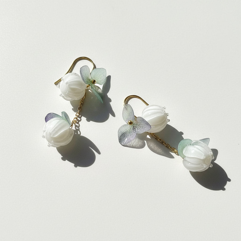 Floral earrings with white and light green flowers on a white background