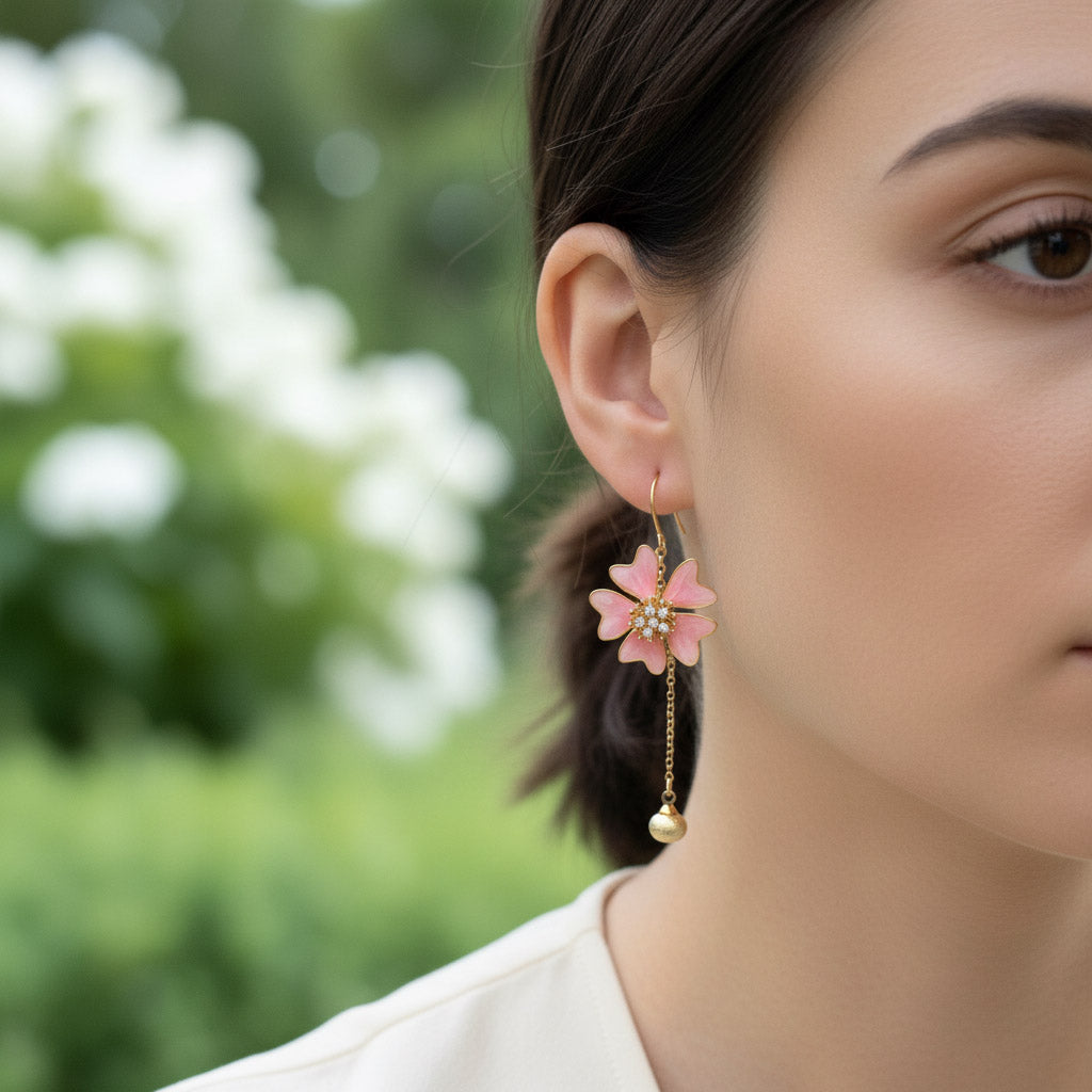 Close-up of a woman wearing pink floral earrings with a blurred green background