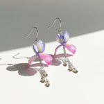 Pair of colorful earrings with floral designs on a light background