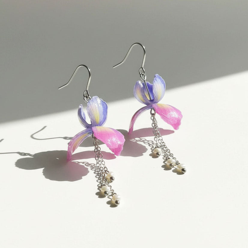 Pair of colorful earrings with floral designs on a light background