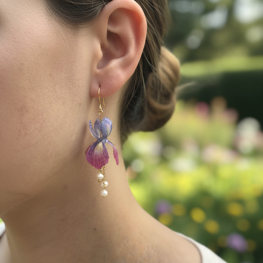 Close-up of a person wearing a floral earring with a blurred garden background