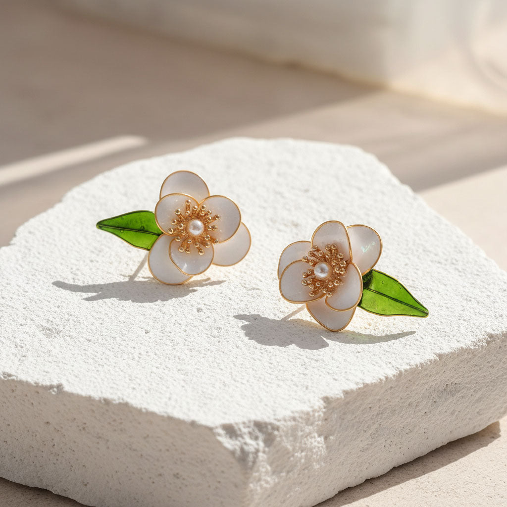 Floral earrings with pearl center on a white stone surface