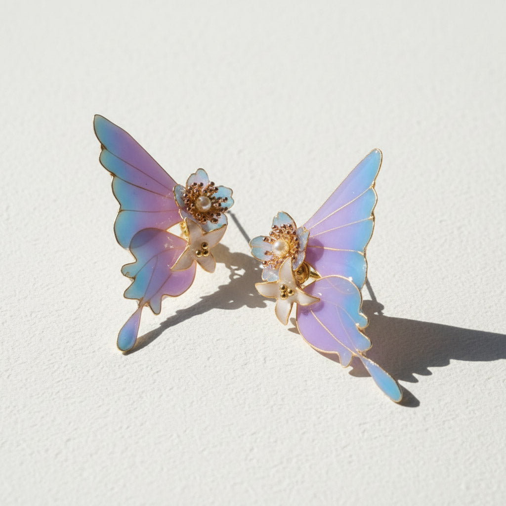 Butterfly-shaped earrings with iridescent wings on a light background