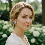 Woman with styled hair and earrings in a garden setting