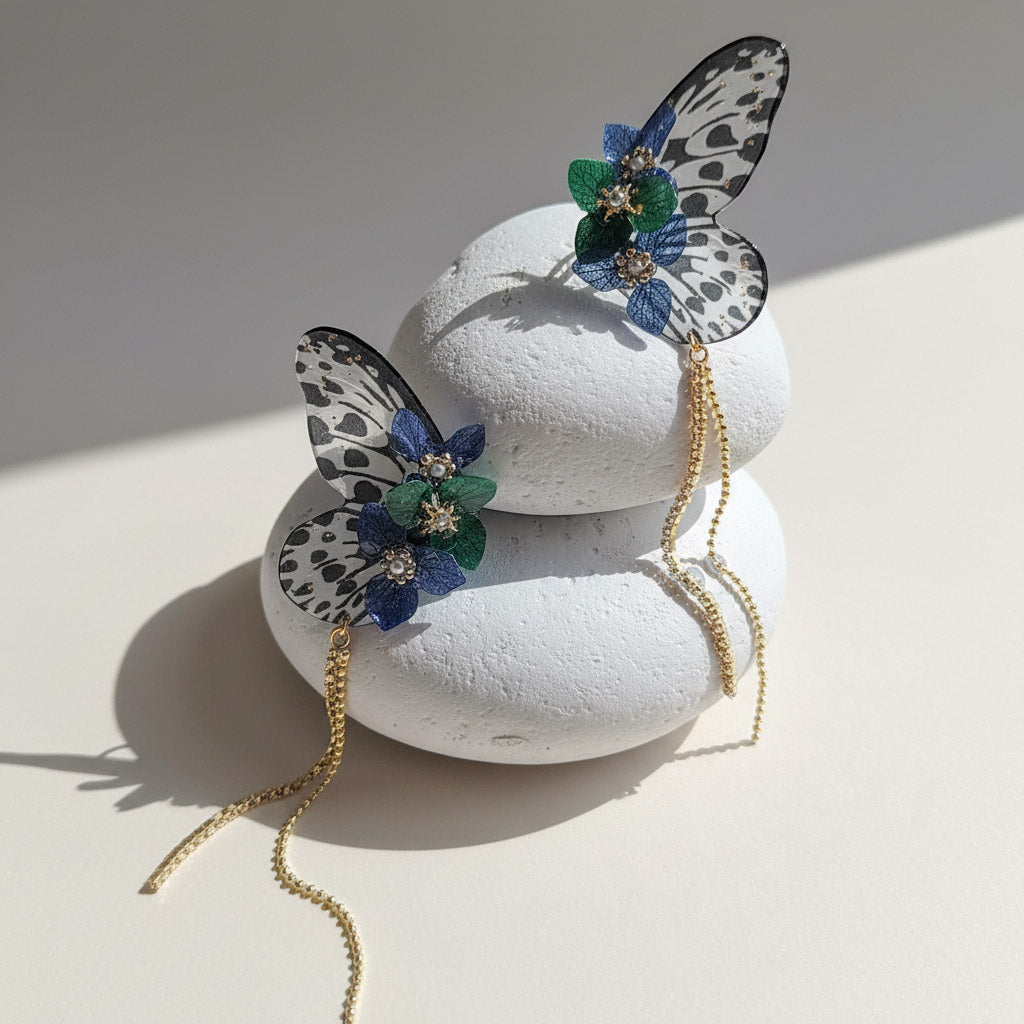 Butterfly-shaped earrings on a white stone surface