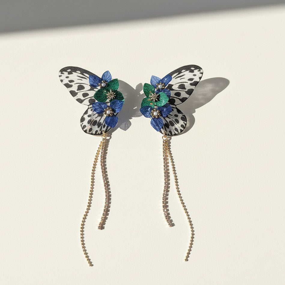 Butterfly-shaped earrings with floral details on a light background