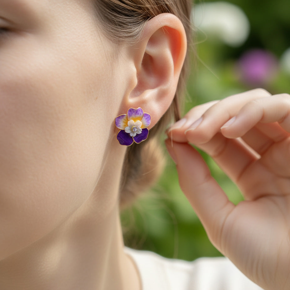 Close-up of a person wearing a floral earring with a blurred green background