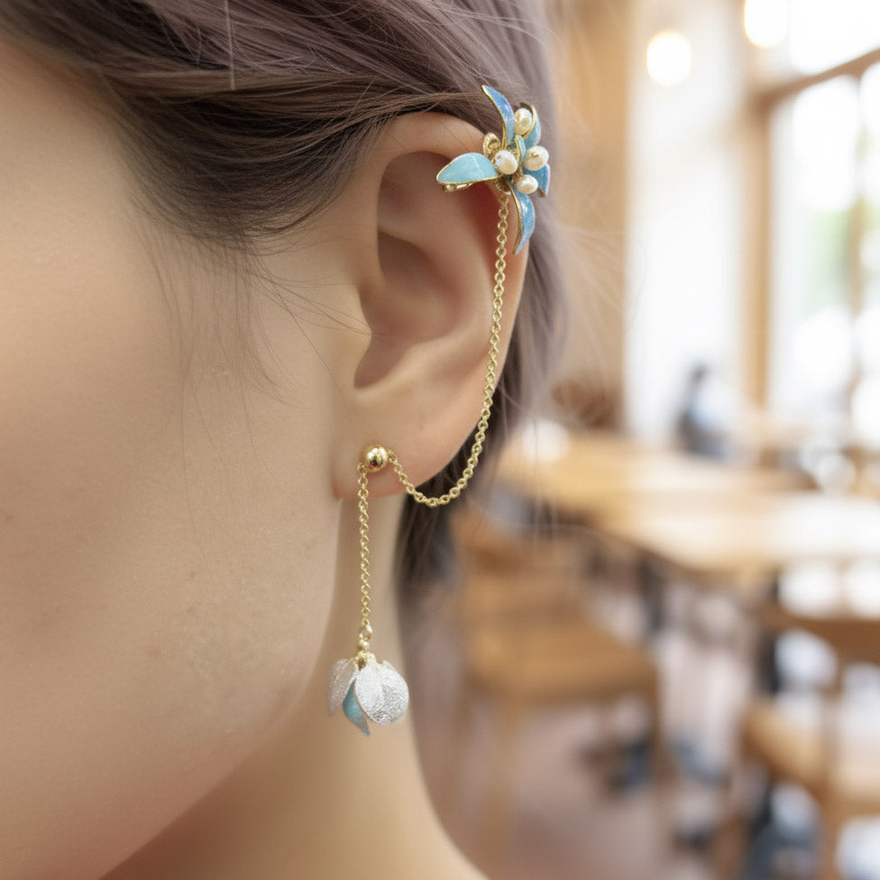 Close-up of a person wearing floral ear cuff with blurred indoor background
