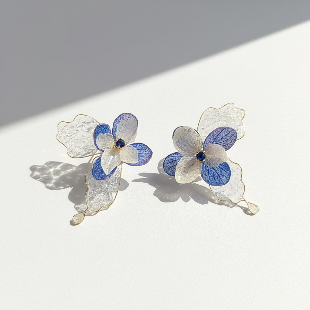 Pair of floral earrings with blue centers on a light background