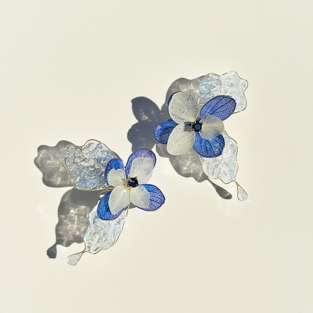 Pair of blue and white floral earrings on a light background