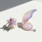 Butterfly and flower-shaped earrings with pearl accents on a light background