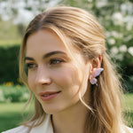 Woman with blonde hair and floral earrings outdoors