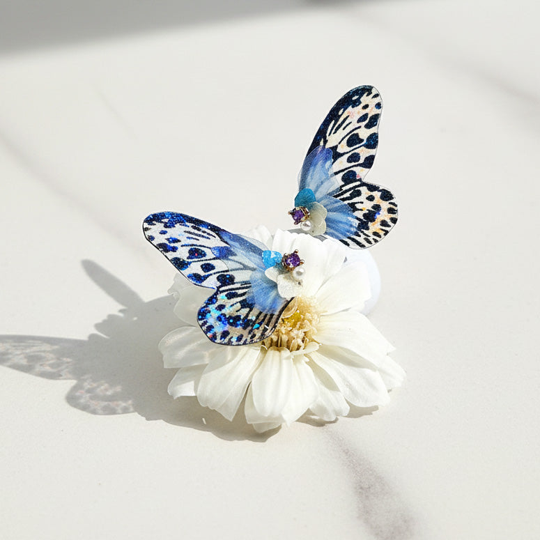 Butterfly-shaped  earrings on a white flower against a light background