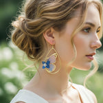 Woman wearing a butterfly earring with a blurred green background