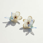 Butterfly-shaped earrings with floral details on a light background