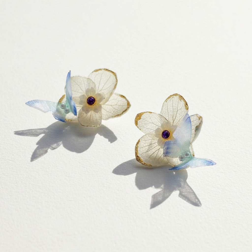 Butterfly-shaped earrings with floral details on a light background