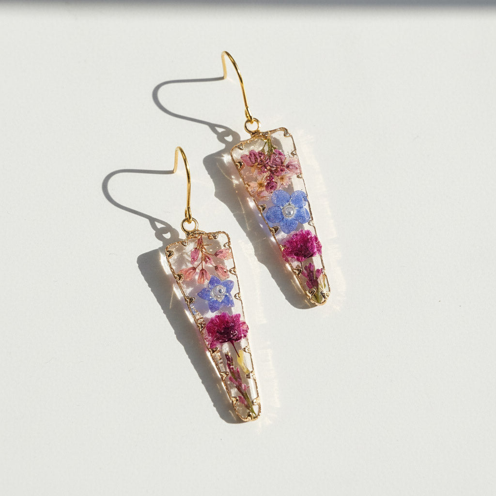 Pair of floral earrings with gold hooks on a white background