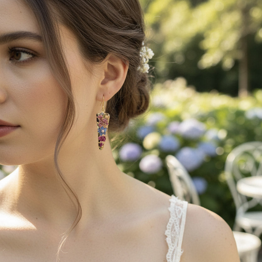 Close-up of a woman wearing colorful earrings with a garden background