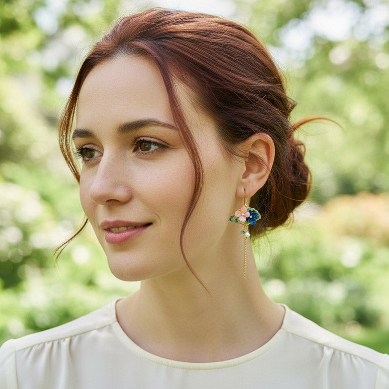Model wearing hydrangea and crane mismatched enamel earrings by A2K London