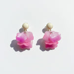 Pair of pink flower-shaped earrings on a light background