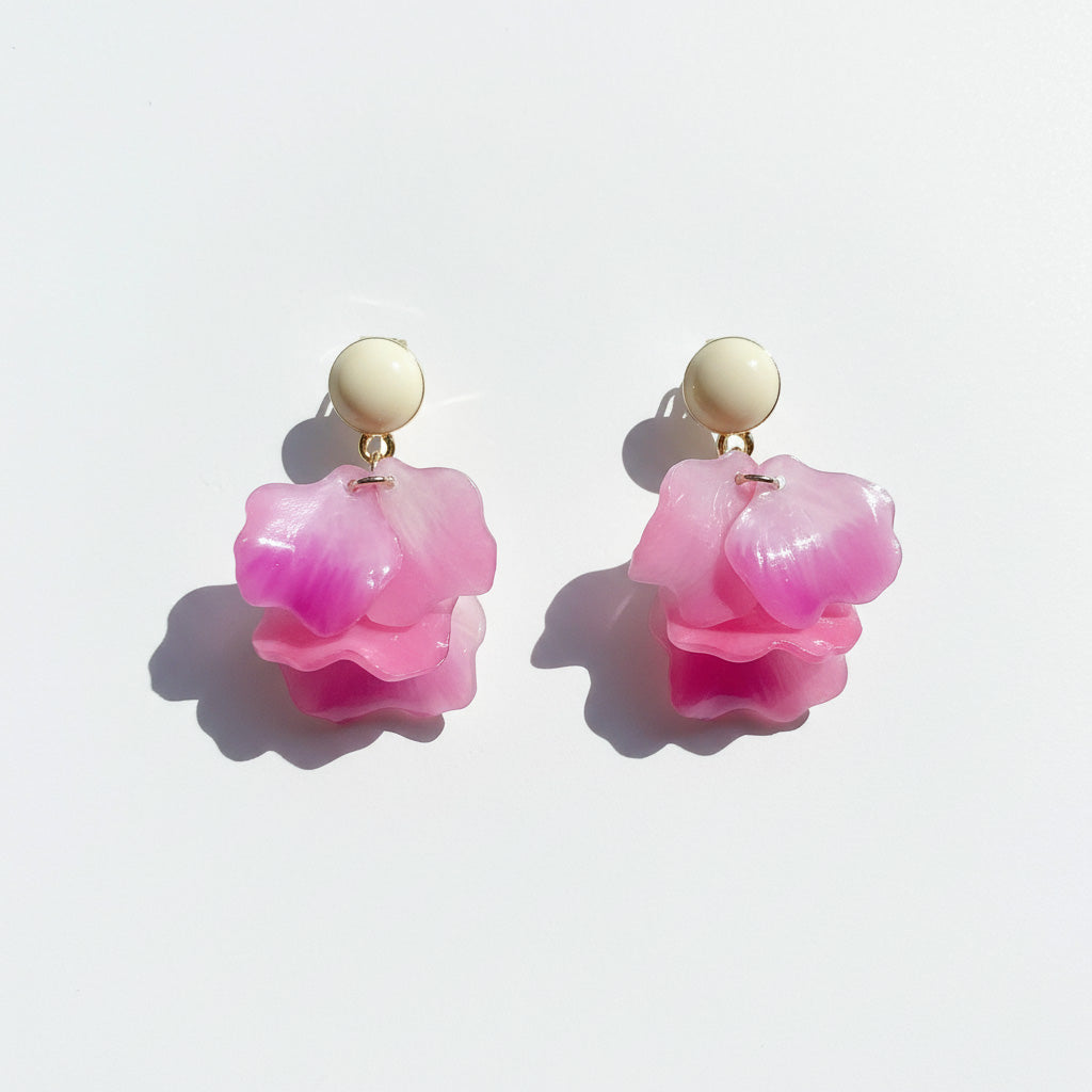 Pair of pink flower-shaped earrings on a light background