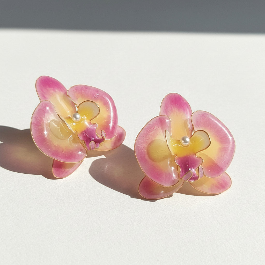 Pair of pink and yellow flower-shaped earrings on a white background