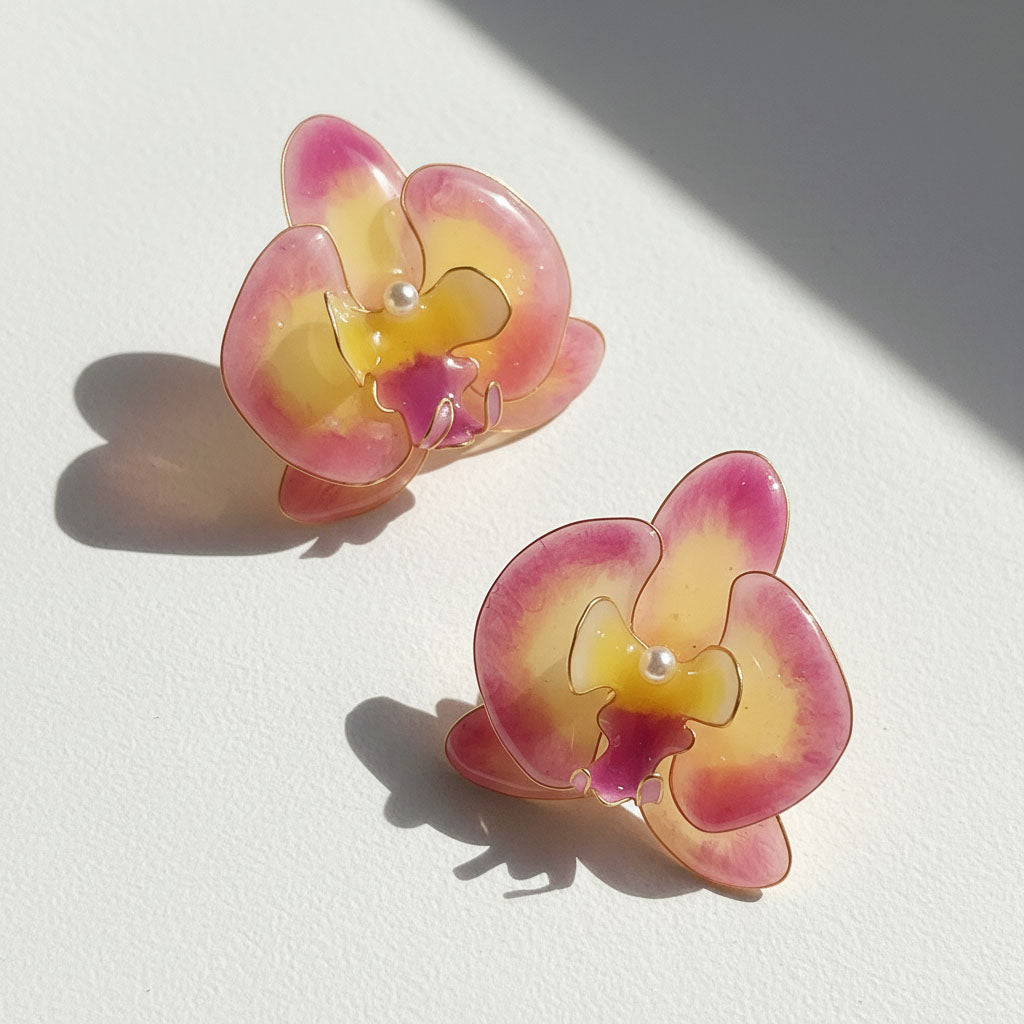 Pair of pink and yellow flower-shaped earrings on a white background