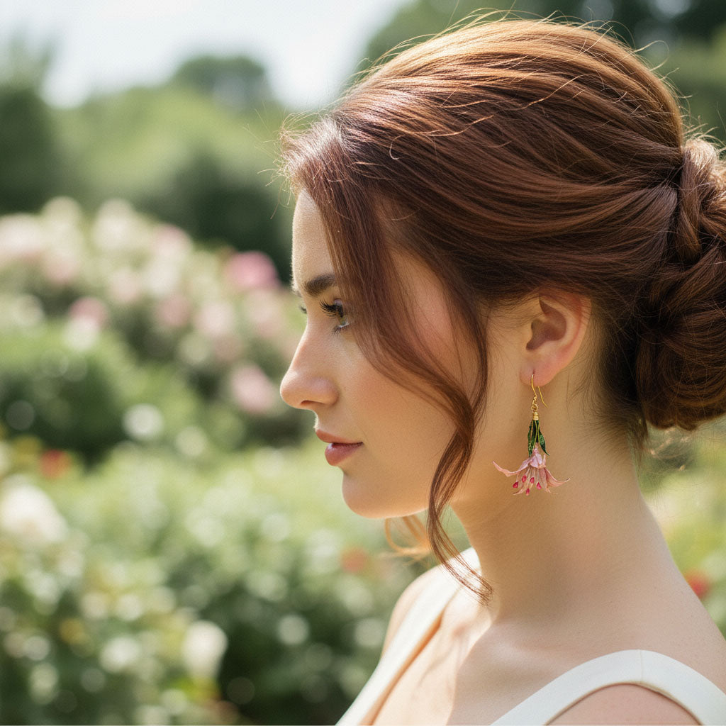 Woman with a braided hairstyle wearing floral earrings in a garden setting