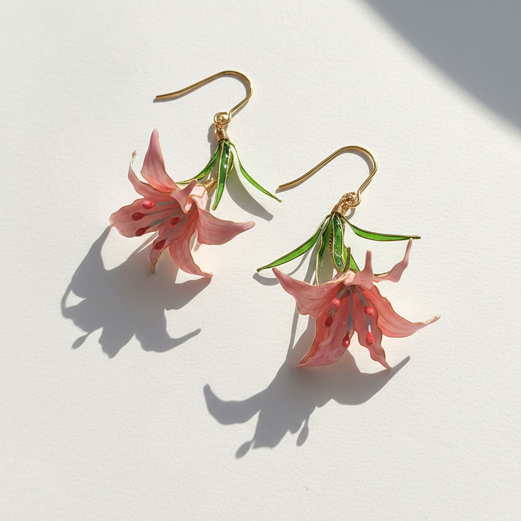 Pair of pink floral earrings on a white background