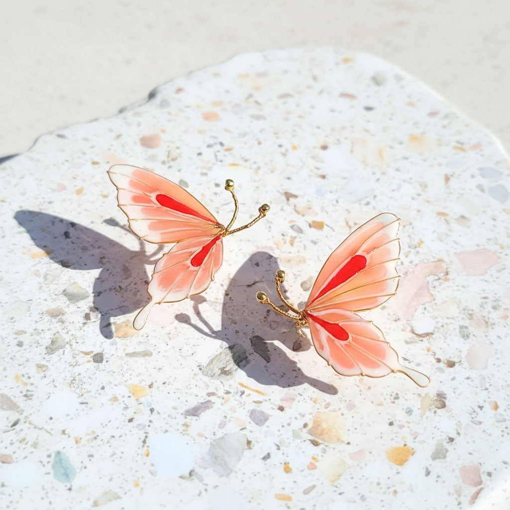 Butterfly-shaped earrings on a textured surface